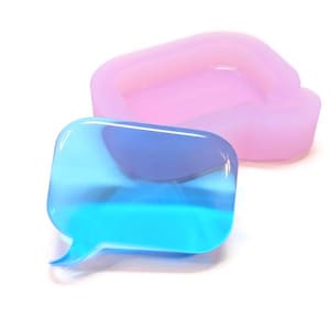 Könnte beinhalten: Zwei Silikonformen in Form von Sprechblasen. Eine ist transparent blau, die andere ist rosa-lila. Die Formen sind für das Basteln oder die Herstellung von Dekorationsartikeln konzipiert.