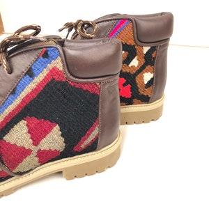 May include: A pair of brown leather ankle boots with colorful woven fabric panels. The boots have a lace-up closure and a chunky sole.