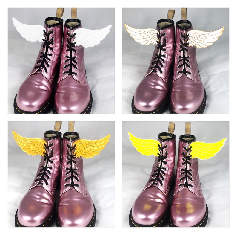 May include: A pair of pink leather boots with black laces and white and yellow angel wings attached to the laces.