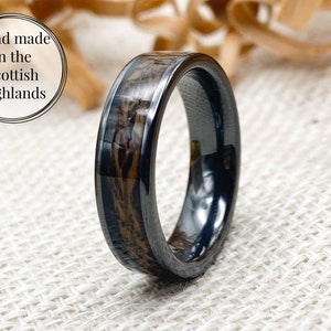 May include: A black and brown wood ring with a black ceramic band. The ring is hand-made in the Scottish Highlands.