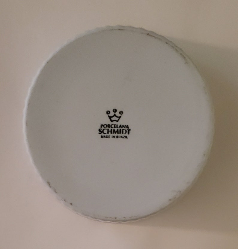 May include: White porcelain bowl with a black logo that reads "Porcelana Schmidt Made in Brazil" and a crown above the text.
