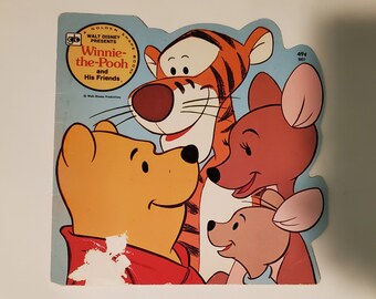Puede incluir: Libro infantil vintage titulado "Winnie-the-Pooh and His Friends". La portada presenta ilustraciones de Winnie the Pooh, Tigger, Kanga y Roo. El libro tiene un borde azul claro y el precio está marcado como 49¢.