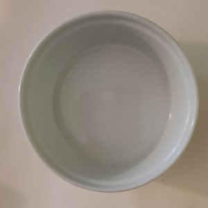 May include: White ceramic bowl with a smooth, glossy finish. The bowl is empty and appears to be new.