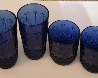 May include: Four cobalt blue glass tumblers with a leaf pattern. The tumblers are all the same design but vary in size.