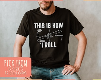 May include: Black t-shirt with a white graphic of a small airplane and the text "This is how I roll". The graphic shows the airplane in flight with a diagram of the roll attitude angle, local horizon, and rolling movement.