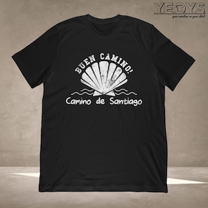 May include: Black t-shirt with a white graphic of a seashell and the text "Buen Camino! Camino de Santiago".