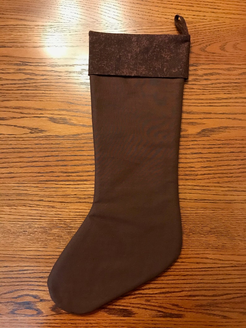 May include: A brown Christmas stocking with a brown and white patterned cuff.