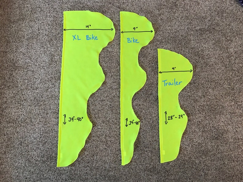 May include: Three yellow fabric pieces with measurements marked in inches. The largest piece is labeled "XL Bike" and measures 14 inches wide by 39-40 inches long. The middle piece is labeled "Bike" and measures 9 inches wide by 34-36 inches long. The smallest piece is labeled "Trailer" and measures 9 inches wide by 28-29 inches long.