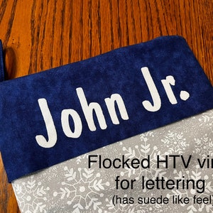 Puede incluir: Una media azul con un patr&oacute;n de copo de nieve blanco y el nombre "John Jr." en letras blancas de vinilo flocado HTV. Las letras tienen una sensaci&oacute;n similar al ante.