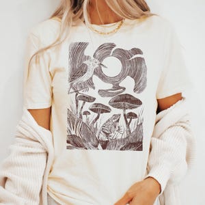 Maglietta Cottagecore con grafica forestale, rana, uccello e funghi, natura