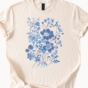 ヴィンテージ風の青い花束グラフィックTシャツ、ナチュラルカラー、レトロな植物の花のデザイン、美しい自然愛好家へのギフト