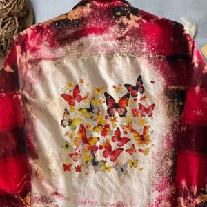 Könnte beinhalten: Rotes und schwarzes kariertes Flanellhemd mit Bleich-Effekt und einem grafischen Druck von bunten Schmetterlingen auf der Rückseite.