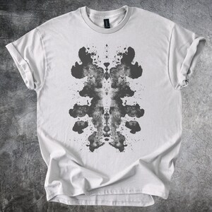 抽象的なインクの染み模様のグラフィックTシャツ、左右対称のアートデザイン、ユニセックス