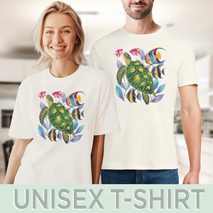 May include: Off-white unisex t-shirts with a sea turtle design. The graphic features a green and yellow turtle, fish, and blue and purple foliage. The text "UNISEX T-SHIRT" is displayed at the bottom of the image.