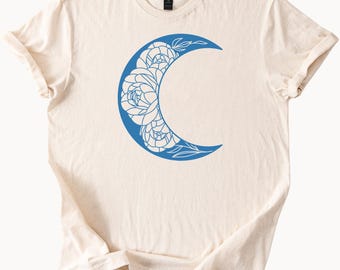 Maglietta con luna crescente e motivi floreali, maglietta grafica celeste, stile boho