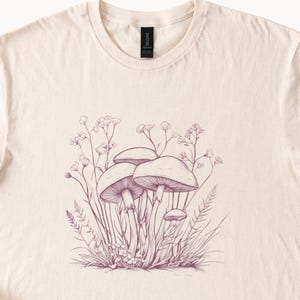 Maglietta grafica boho con funghi, schizzi botanici di funghi disegnati a mano, design cottagecore ispirato alla natura e ai fiori selvatici.