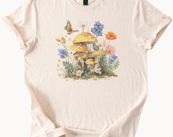 Camiseta con estampado de hongos y flores silvestres con mariposas, estilo botánico inspirado en la naturaleza, estilo cottagecore.