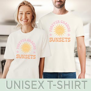 May include: White unisex t-shirt featuring a pink and yellow sun graphic with the text "Forever Chasing Sunsets".