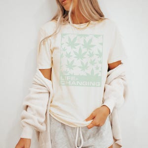 Camiseta con estampado de hoja de marihuana que te cambia la vida, con vibras de fumeta