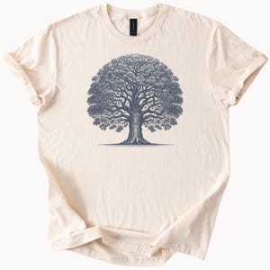 May include: A cream-colored t-shirt with a blue illustration of a large tree with a thick trunk and many branches.