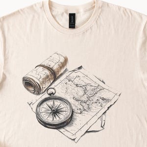 Camiseta con brújula y mapa, color beige. La aventura te espera. Viajes. Pasión por los viajes. Regalo de explorador.