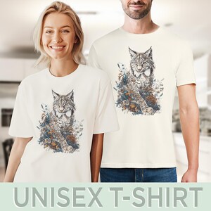 May include: Off-white unisex t-shirts featuring a detailed illustration of a lynx surrounded by flowers and foliage. The lynx is depicted in shades of gray, brown, and white, with the floral elements in blue, green, and brown. The text "UNISEX T-SHIRT" is at the bottom.