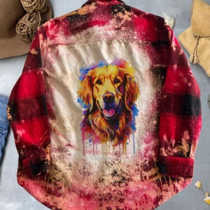 May include: Red and black plaid flannel shirt with a watercolor painting of a golden retriever dog on the back. The shirt has a distressed, bleached look.