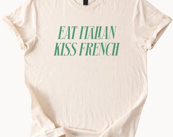 イタリア料理を食べる、フランス語にキスするグラフィックTシャツ。食通の旅行にインスパイアされた、トレンディで美しいステートメントTシャツ。彼女や彼への楽しい名言ギフト。