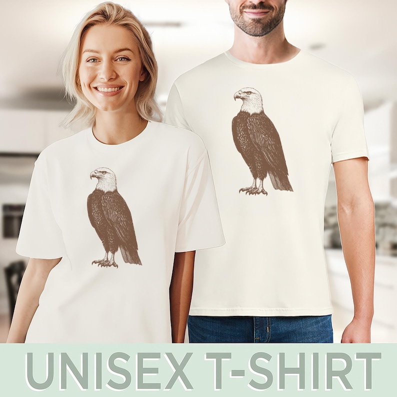 May include: Two white t-shirts with a brown bald eagle graphic printed on the front. The eagle is facing right and has a white head and tail feathers.