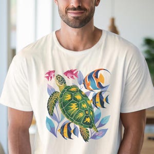 May include: White t-shirt with a vibrant design of a sea turtle, tropical fish, and foliage. The turtle's shell is green and yellow, while the fish are various colours. The leaves are blue and purple. A casual, summery design.