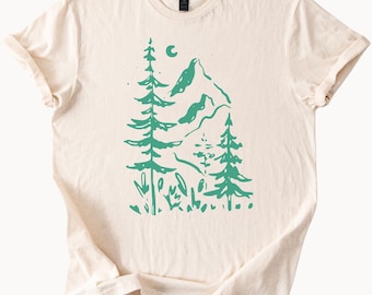 Camiseta unisex de algodón suave con estampado de bosque de montaña y luna, diseño inspirado en la naturaleza con una hilera de pinos altos. Ideal para amantes del senderismo y las actividades al aire libre.