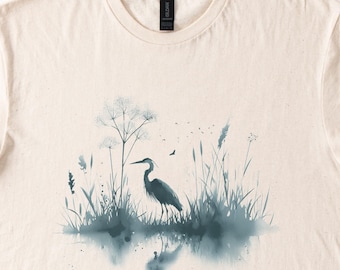 May include: A watercolor illustration of a heron standing in a marsh with tall grasses and a blue-grey color scheme.