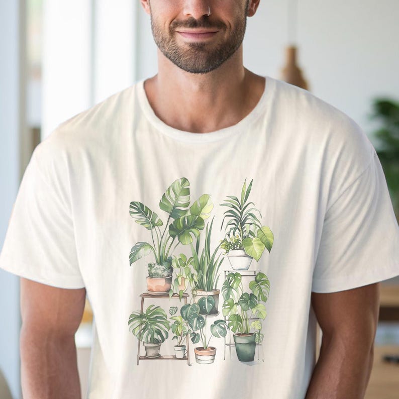 Puede incluir: Camiseta blanca con una ilustraci&oacute;n de acuarela de plantas en macetas, incluyendo Monstera y otras hojas verdes. Las plantas est&aacute;n dispuestas en estantes de madera, creando un tema bot&aacute;nico. La camiseta tiene un cuello redondo simple.