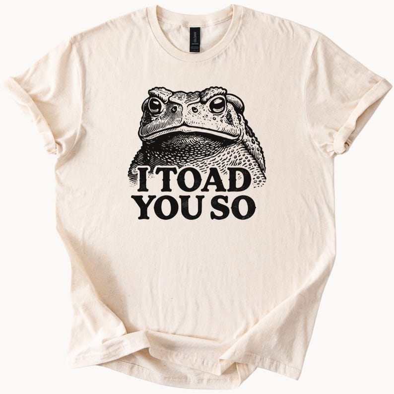 May include: A beige t-shirt with a black and white illustration of a toad and the text "I TOAD YOU SO".