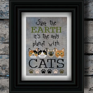 Puede incluir: Imagen enmarcada de punto de cruz en un marco negro. La obra de arte presenta el texto "Save the EARTH it's the only planet with CATS" encima de cuatro caras de gato y huellas de patas. El fondo es gris claro.