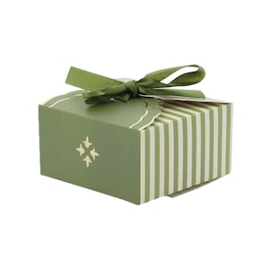 Pode incluir: Uma pequena caixa de presente verde-oliva com uma fita verde a condizer amarrada em laço. A caixa tem riscas verticais creme nas laterais e um emblema dourado. Ideal para pequenos presentes.