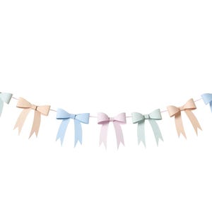 Könnte beinhalten: Eine Girlande aus pastellfarbenen Schleifen in Rosa, Blau, Grün und Pfirsich. Die Schleifen sind auf einer dünnen weißen Schnur aufgereiht und bilden ein dekoratives Banner. Ideal für eine Babyparty oder Party.