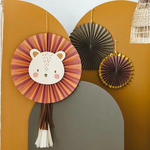 Può includere: Un set di tre decorazioni a ventaglio di carta in tonalità marrone, oro e rosa. Il ventaglio centrale presenta un simpatico viso di animale con naso e occhi marroni. I ventagli sono perfetti per un baby shower o una festa di compleanno.