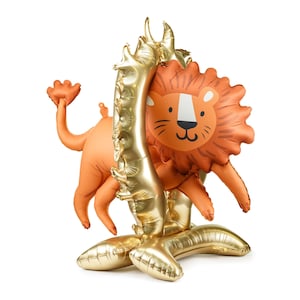 Puede incluir: Un arco de globos dorados con un globo de león en el centro. El globo de león tiene una cara marrón con ojos negros y una nariz rosa.