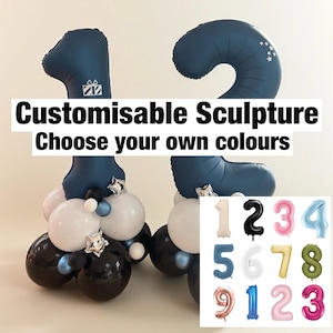 Könnte beinhalten: Eine marineblaue Ballon-Skulptur der Zahl 12 mit einer Basis aus weißen, schwarzen und blauen Ballons. Der Text "Customisable Sculpture Choose your own colours" wird angezeigt. Zusätzliche Zahlenballons sind abgebildet.