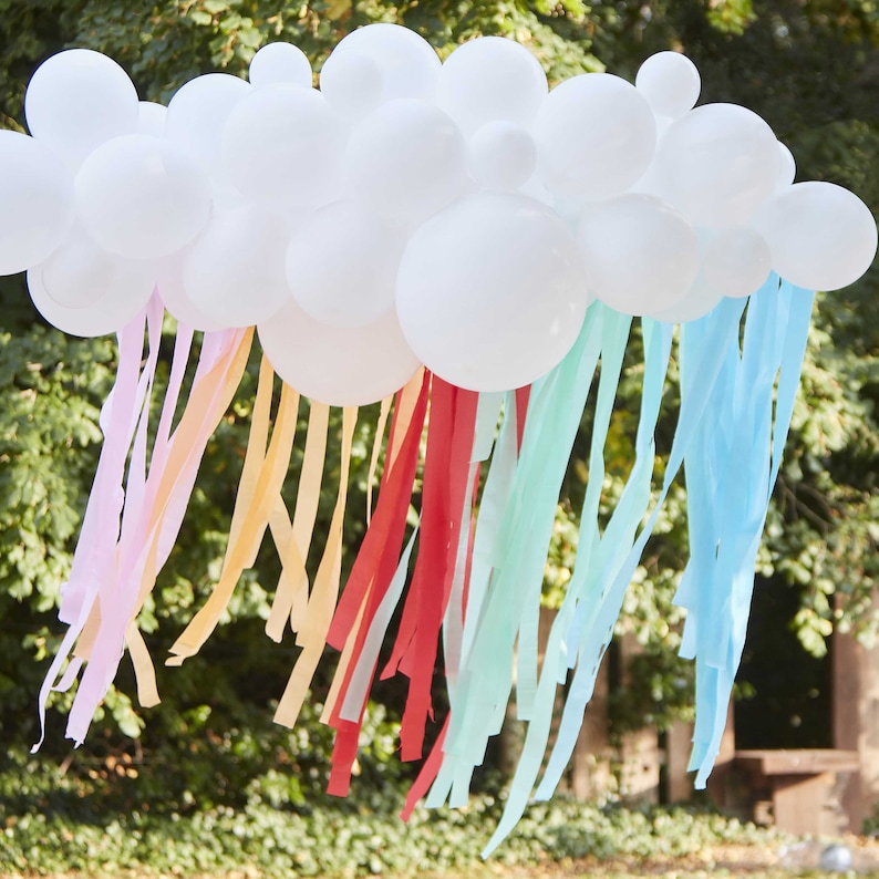 May include: A white balloon cloud with colorful streamers hanging down. The streamers are pink, orange, yellow, red, light blue, and blue.