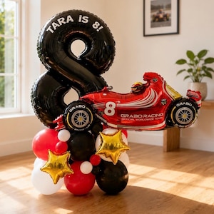May include: A balloon arrangement featuring a large black number 8 balloon with the text TARA is 8! and a red race car balloon labelled GRABO RACING. The base consists of a cluster of red, black, white, and gold star-shaped foil balloons.
