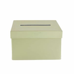 May include: A pale green rectangular box with a lid. The lid features a thin, horizontal black slit. The box is a solid colour and appears to be made of cardboard or similar material. The box is likely used for collecting ballots or donations.