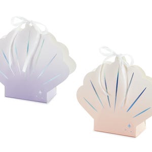 May include: Two decorative seashell-shaped gift boxes with white satin ribbon bows. The boxes are made of cardboard and have a gradient color design. One box is purple and the other is pink.
