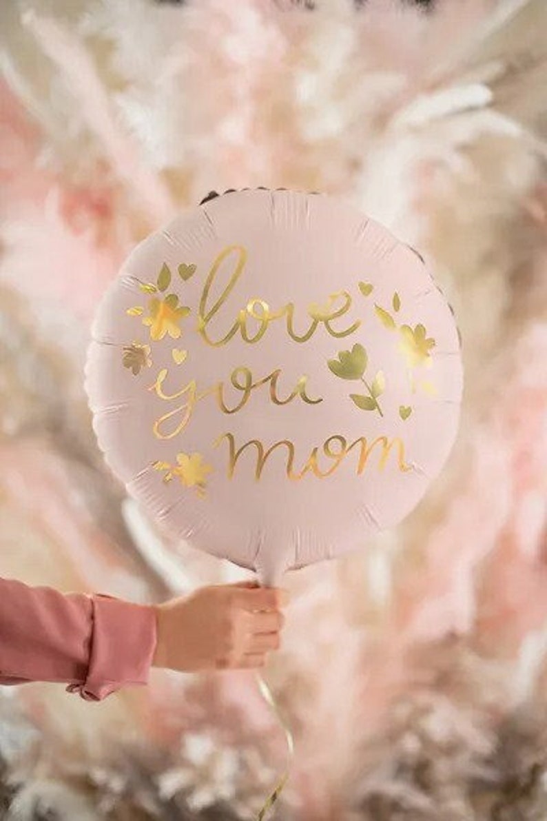 May include: A pink balloon with gold lettering that says "love you mom" and gold floral accents.