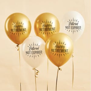 May include: Five balloons, gold and white, with black text. The gold balloons say "Happy Retirement" and the white balloons say "Retired Not Expired". The balloons are tied with gold ribbon.