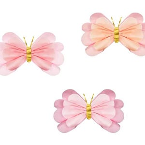 May include: Three paper butterflies with gold accents. The butterflies are pink and peach in color.