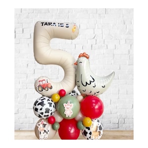 Puede incluir: Un arreglo festivo de globos con un gran número 5, con el texto "TARA IS 5". El arreglo incluye un globo con forma de pollo, globos con estampado de vaca y otros globos coloridos con pegatinas de animales de granja. Sobre un fondo de ladrillo blanco.