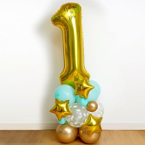 May include: Gold number one balloon with the text "George is One" and a cluster of blue, gold, and white balloons.