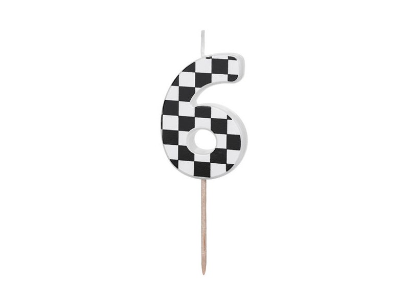 May include: Black and white checkered number six birthday candle. The candle is on a wooden stick.